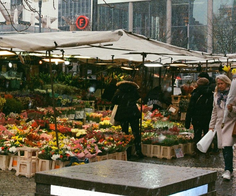 Marktstände auf einem Markt mit Menschen, die einkaufen.